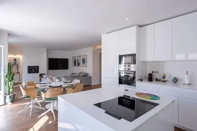 a kitchen with white cabinets and a living room at Luxury Apt With Balcony On Famous Rue D'antibes! - Kiss Apartment by Halldis in Cannes