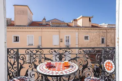 a table on a balcony with two cups on it at Luxury Apt With Balcony On Famous Rue D'antibes! - Kiss Apartment by Halldis in Cannes