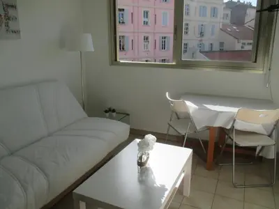 a living room with a couch and a table and a window at Studio à 5 minutes à pied des plages et de la croisette in Cannes