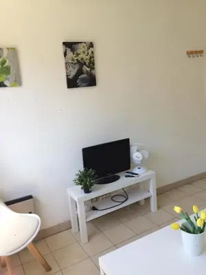 a living room with a tv on a white table at Studio à 5 minutes à pied des plages et de la croisette in Cannes