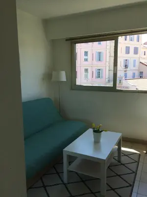 a living room with a couch and a table and a window at Studio à 5 minutes à pied des plages et de la croisette in Cannes