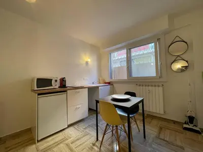 a small kitchen with a table and a microwave at Beau studio - 100m de la plage Palm beach in Cannes