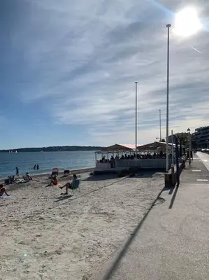 a group of people sitting on a beach at Beau studio - 100m de la plage Palm beach in Cannes