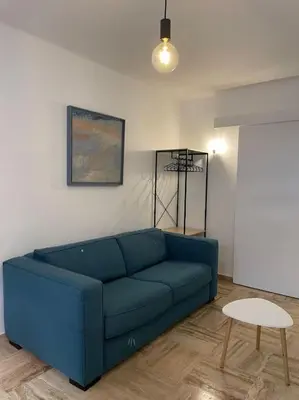 a living room with a blue couch and a table at Beau studio - 100m de la plage Palm beach in Cannes