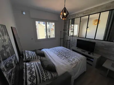 a bedroom with a bed and a flat screen tv at Modern and pleasant apartment in the heart of the city in Cannes