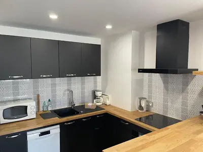 a kitchen with black cabinets and a white microwave at Modern and pleasant apartment in the heart of the city in Cannes