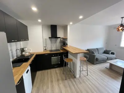a kitchen and living room with a couch and a table at Modern and pleasant apartment in the heart of the city in Cannes