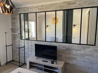 a living room with a tv on a brick wall at Modern and pleasant apartment in the heart of the city in Cannes