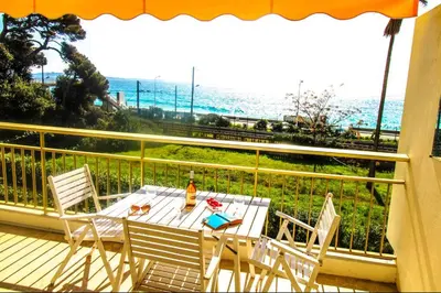 a table and chairs on a balcony with a view of the ocean at Le Trident in Cannes