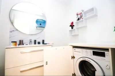 a laundry room with a washing machine and a mirror at Le Trident in Cannes