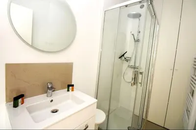 a bathroom with a sink and a shower with a mirror at Le Trident in Cannes