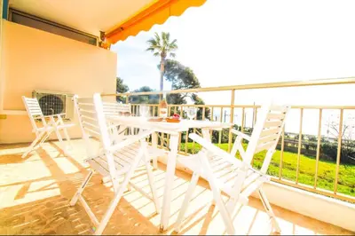 a white table and chairs on a balcony at Le Trident in Cannes