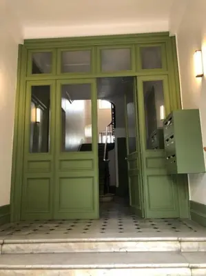 a large green door in a building with at Appartement sous les toits 5 min du palais à pied in Cannes