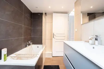 a bathroom with a white tub and a sink at Appartement sous les toits 5 min du palais à pied in Cannes