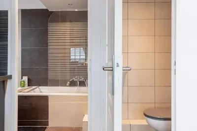 a bathroom with a tub and a toilet and a sink at Appartement sous les toits 5 min du palais à pied in Cannes