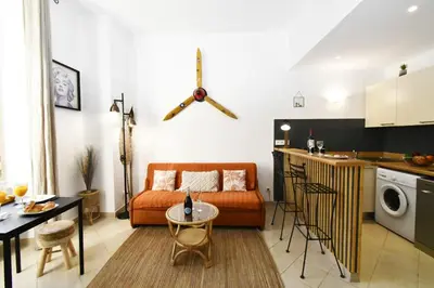 a living room with a couch and a kitchen at Tou'Can YourHostHelper in Cannes