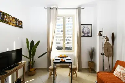 a living room with a table and a window at Tou'Can YourHostHelper in Cannes