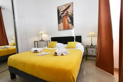 a bedroom with a yellow bed with towels on it at Tou'Can YourHostHelper in Cannes