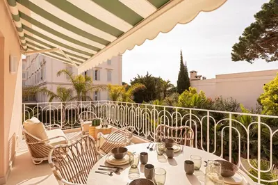 a patio with tables and chairs on a balcony at Maison Carla Rosa Cannes in Cannes