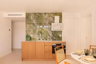 a kitchen with a sink and a table with chairs at Maison Carla Rosa Cannes in Cannes