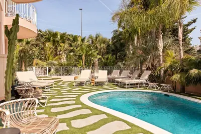 a pool with chaise lounge chairs and avisorvisor at Maison Carla Rosa Cannes in Cannes
