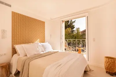 a bedroom with a bed and a large window at Maison Carla Rosa Cannes in Cannes