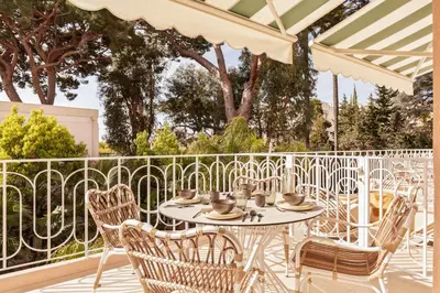 an outdoor patio with a table and chairs at Maison Carla Rosa Cannes in Cannes