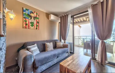 a living room with a couch and a table at Appt Vue Mer Exceptionnelle sur baie de Cannes in Cannes