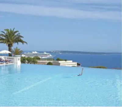 a person swimming in a large pool of blue water at Appt Vue Mer Exceptionnelle sur baie de Cannes in Cannes