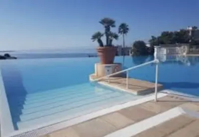 a view of a swimming pool with a palm tree at Appt Vue Mer Exceptionnelle sur baie de Cannes in Cannes