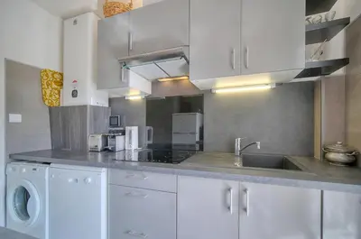 a kitchen with white cabinets and a sink at Le Jak - 2 Pièces - Loggia - VCA in Cannes