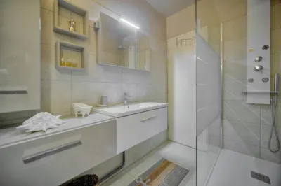 a white bathroom with a sink and a shower at Le Jak - 2 Pièces - Loggia - VCA in Cannes