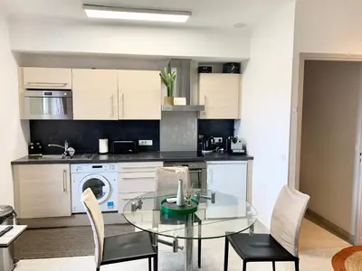 a kitchen with a glass table and chairs in a room at Cannes Centre - 500m Palais de Festival - Banane in Cannes