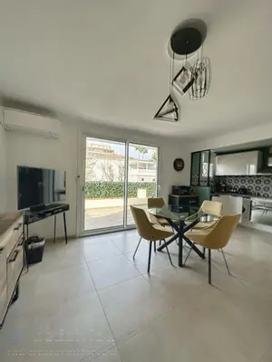 a living room with a table and chairs and a television at AGENCIA appartement 2 Pièces lumineux terrasse in Cannes