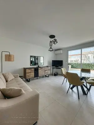 a living room with a couch and a table at AGENCIA appartement 2 Pièces lumineux terrasse in Cannes