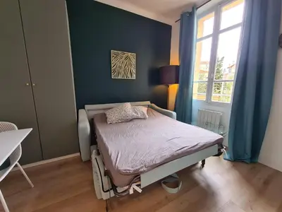 a bedroom with a bed in a room with blue walls at Studio 700 m du Palais et Croisette - Le St Jean in Cannes
