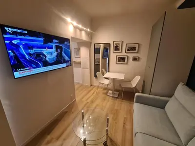 a living room with a couch and a tv on a wall at Studio 700 m du Palais et Croisette - Le St Jean in Cannes