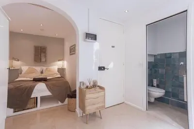 a bedroom with a bed and a bathroom with a toilet at Maison Denise - Suquet vue sur la Cathédrale in Cannes