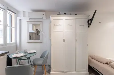 a white cabinet in a living room with a table at Maison Denise - Suquet vue sur la Cathédrale in Cannes