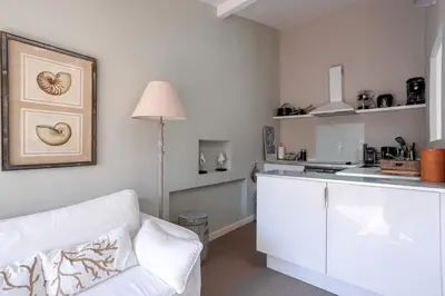 a living room with a white couch and a kitchen at Maison Denise - Suquet vue sur la Cathédrale in Cannes