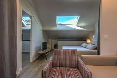 a bedroom with a bed and a couch and a window at 9E - Appartement 1 chambre in Cannes