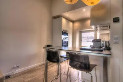 a kitchen with a counter and two stools at a bar at 9E - Appartement 1 chambre in Cannes