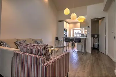 a living room with two couches and a piano at 9E - Appartement 1 chambre in Cannes
