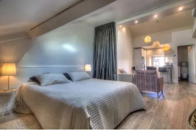 a bedroom with a large bed and a living room at 9E - Appartement 1 chambre in Cannes