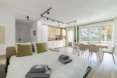 a bedroom with a large bed and a dining room at Montfleury cannes in Cannes