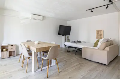 a living room with a dining room table and a bed at Montfleury cannes in Cannes
