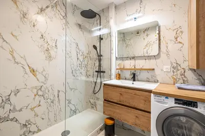 a bathroom with a shower and a sink and a washing machine at Montfleury cannes in Cannes