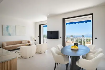 a living room with a table and white chairs at Les DUNES 3 BEDS CROISETTE BEACHES Sea VIEW in Cannes