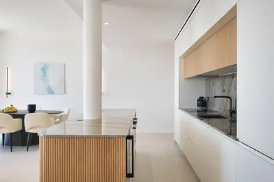 a kitchen and dining room with white walls and wood cabinets at Les DUNES 3 BEDS CROISETTE BEACHES Sea VIEW in Cannes