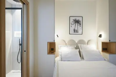 a bedroom with a bed with white sheets and pillows at Les DUNES 3 BEDS CROISETTE BEACHES Sea VIEW in Cannes